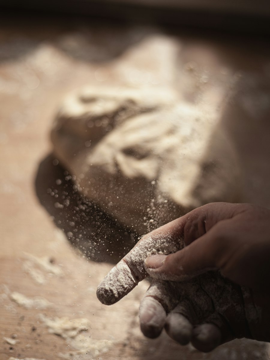 Hands dusted with flour working dough in soft morning light