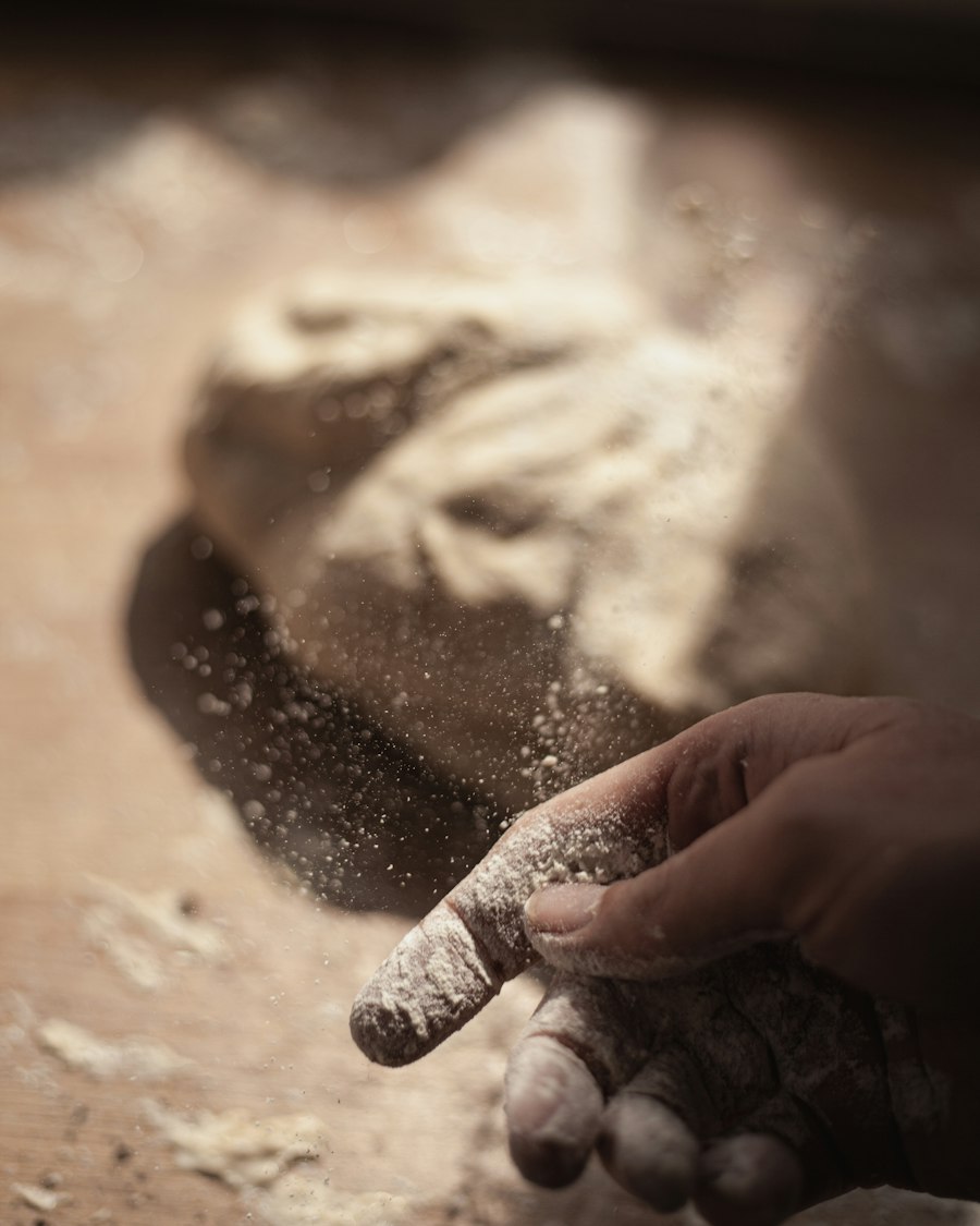 Hands dusted with flour working dough on a table in soft morning light