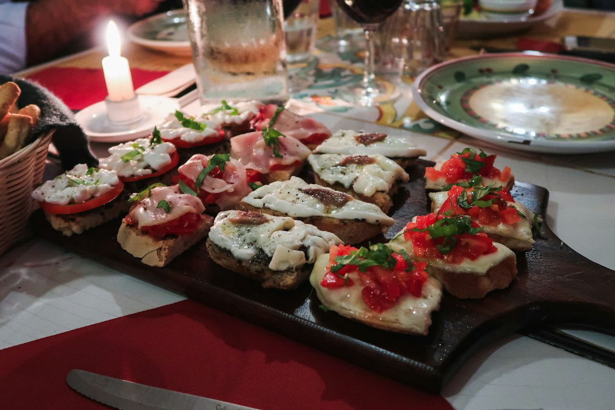 A tray of bruschetta topped with tomato