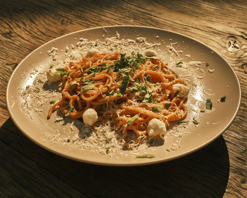 A plate of spaghetti finished with fresh cheese