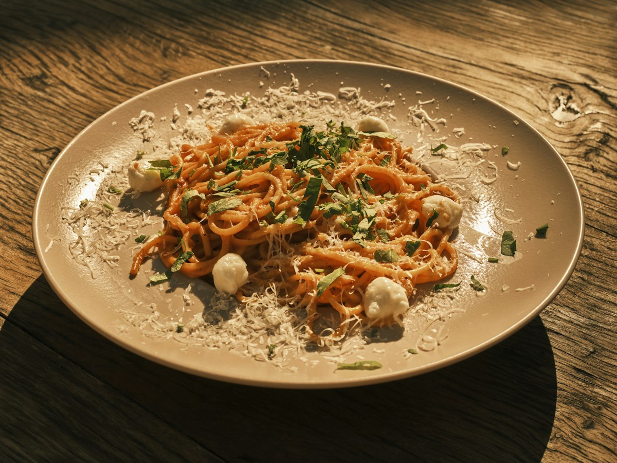 A plate of spaghetti finished with fresh cheese