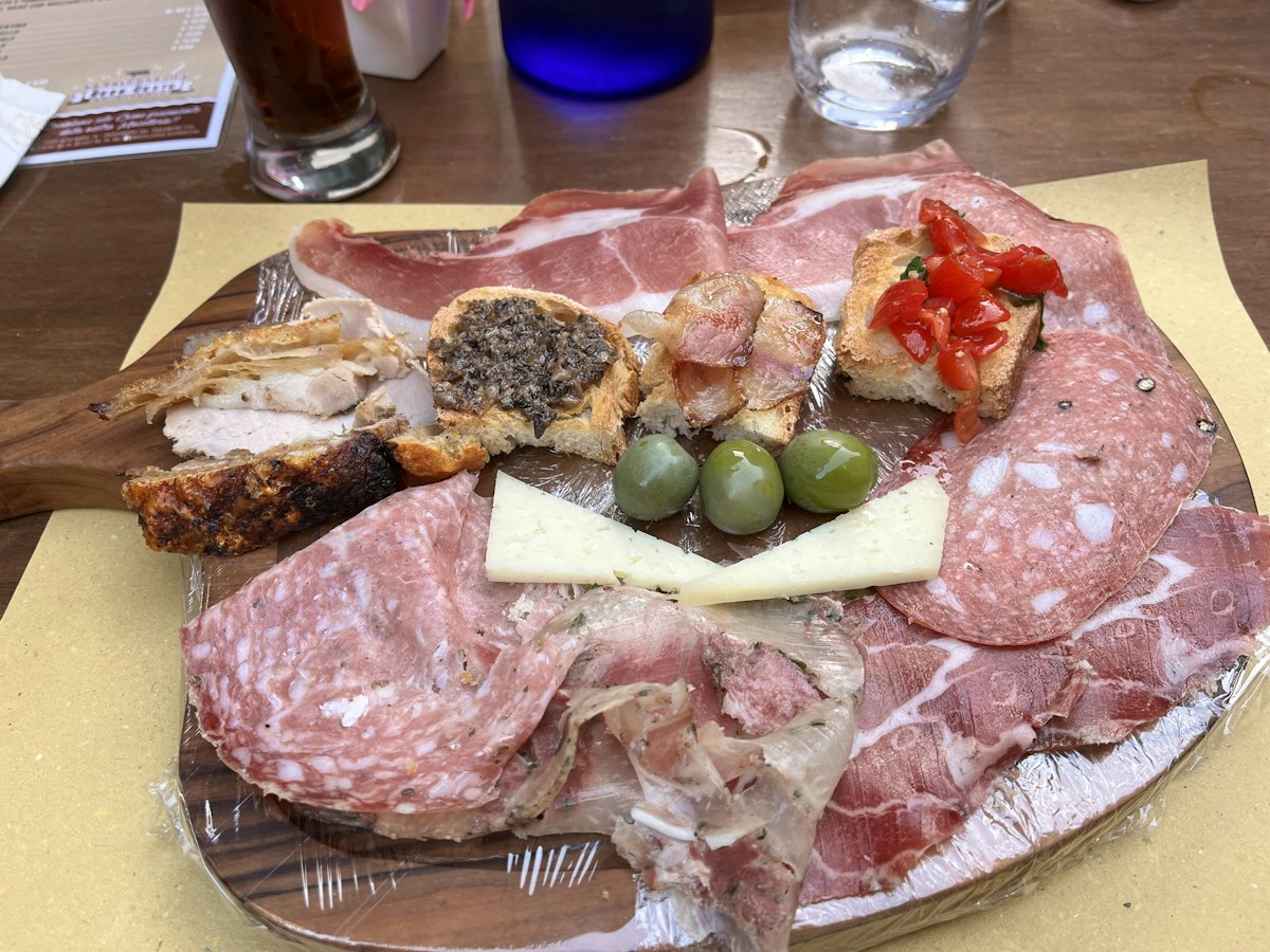 A platter of cured meats and cheeses laid out on a table