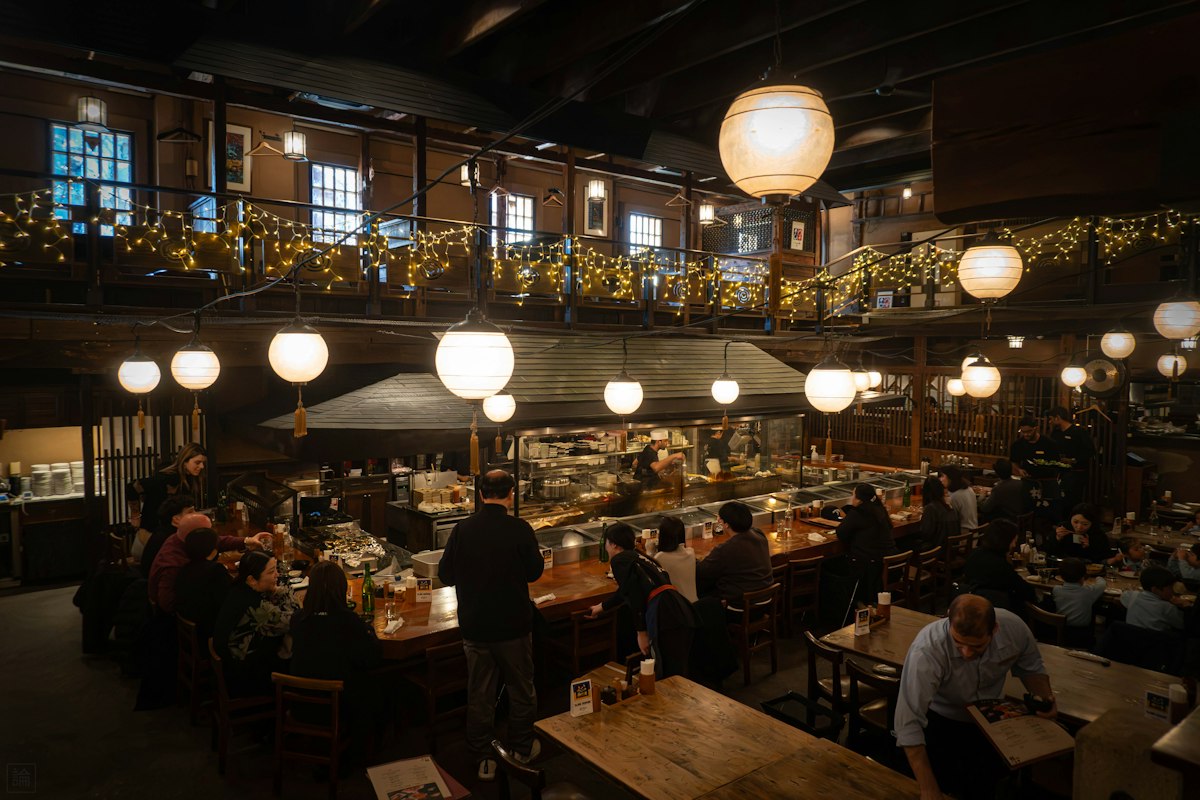 A busy restaurant interior with a bar and warm decorative lighting